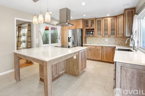 A kitchen with wooden cabinets and a large island.