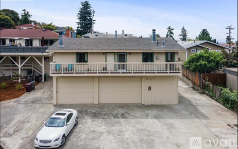 A car is parked in a garage in front of a house.