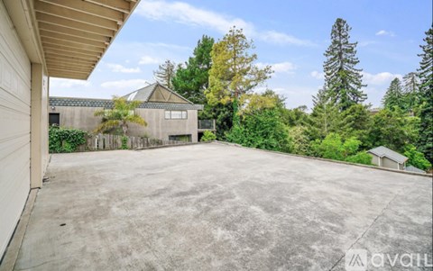 A large, empty driveway leads to a house with a garage.