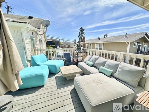A patio with a white couch and blue chairs is available for rent.
