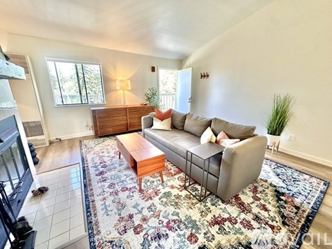 A living room with a couch, coffee table, and rug.