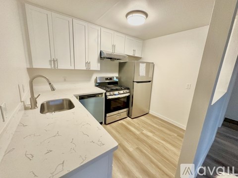 A kitchen with a sink, stove, and refrigerator.