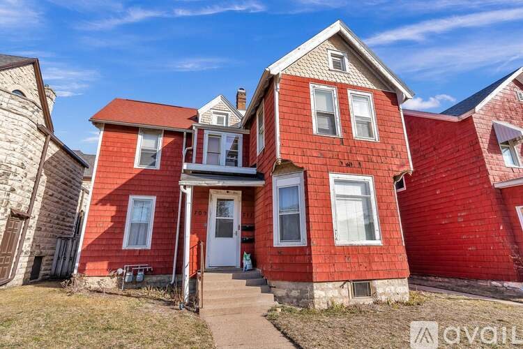 A red brick house with a white door and windows.