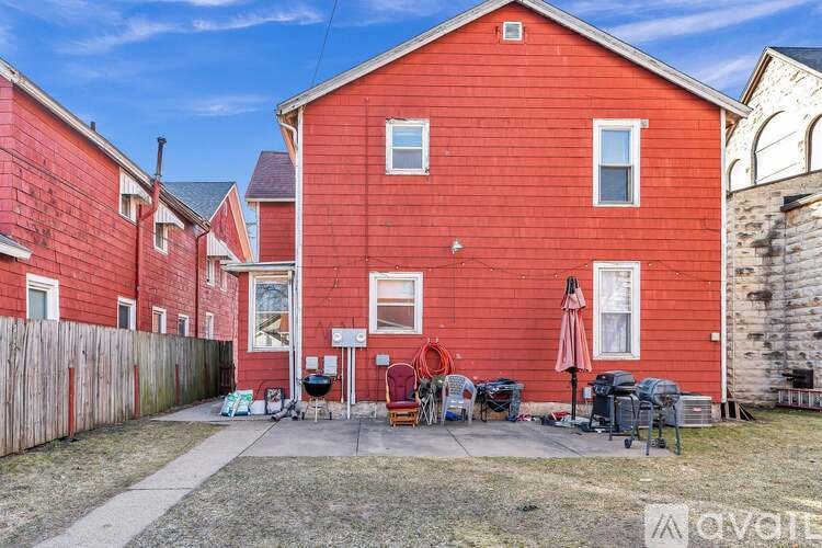 A red house with a patio and outdoor furniture.