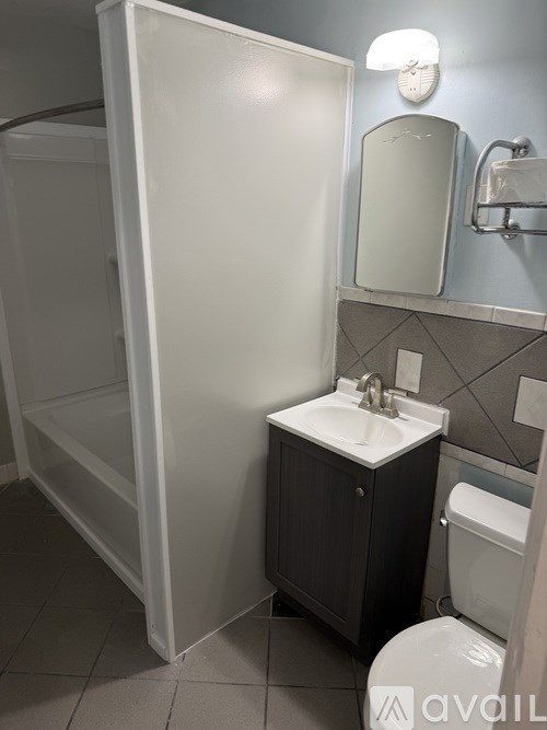 A bathroom with a toilet, sink, and medicine cabinet.