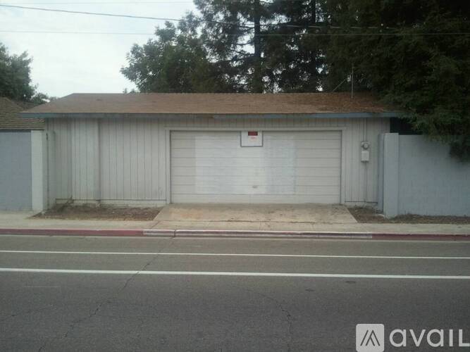 A garage with a white door and a brown roof.