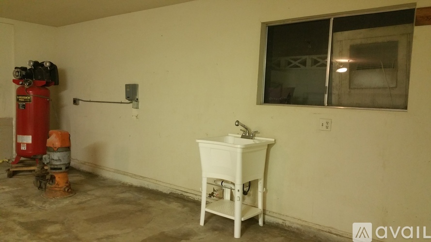 A white sink is in a room with a red fire extinguisher.