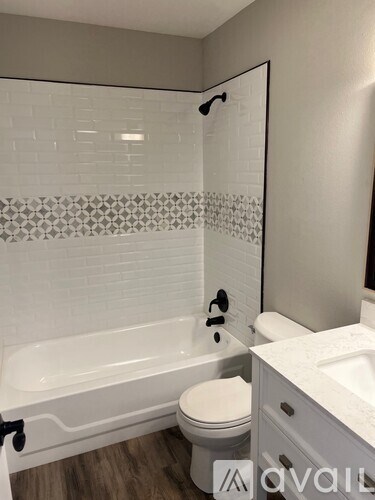 A white bathroom with a tub, toilet and sink.
