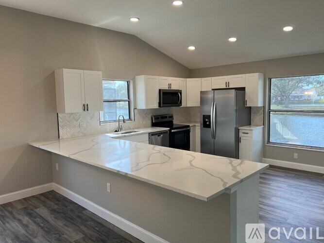 A kitchen with a marble countertop and stainless steel appliances.