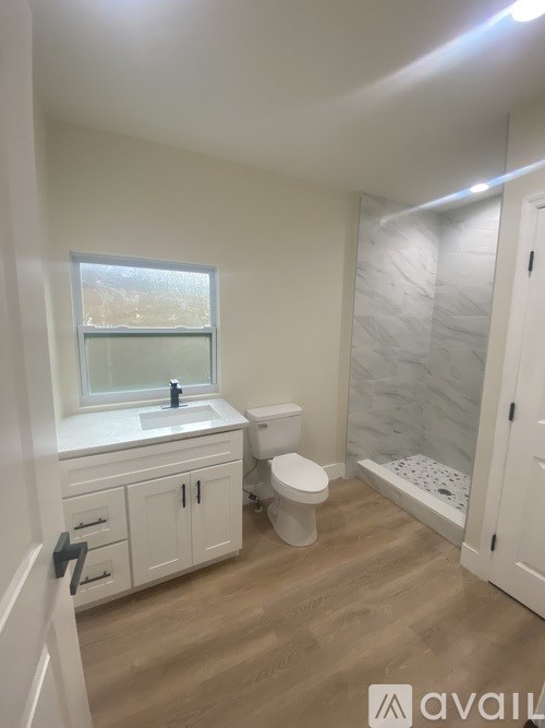 A bathroom with a toilet, sink, and shower.