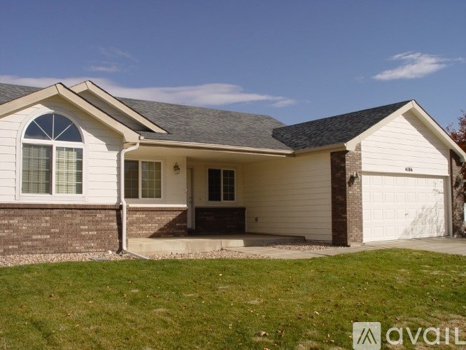 A house with a white garage door and a brick wall.