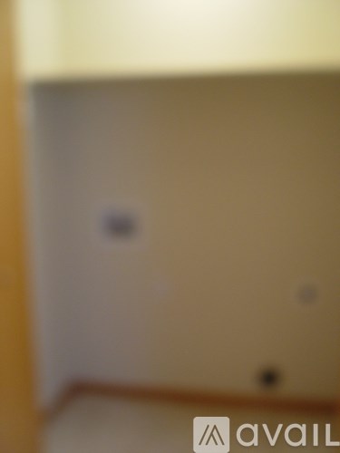 A room with a white wall and a brown floor.