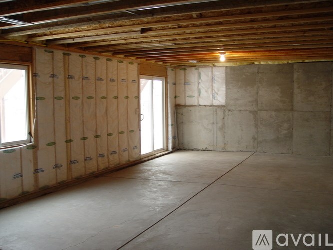 A room under construction with wooden beams and insulation on the walls.