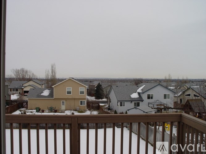A view of a snowy residential area from a balcony.