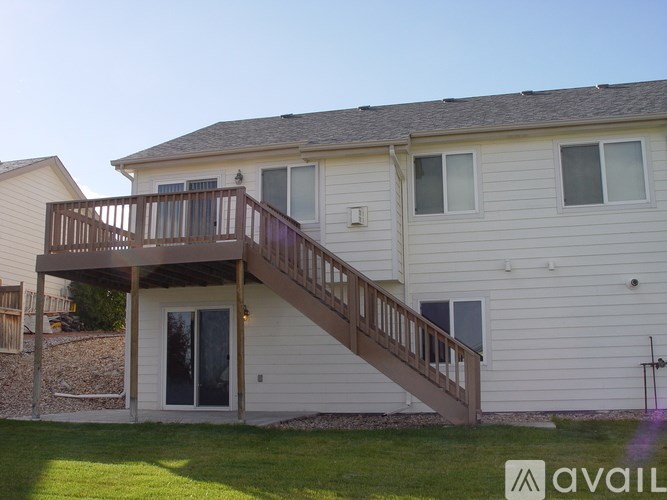 A house with a deck and stairs leading to the second floor.