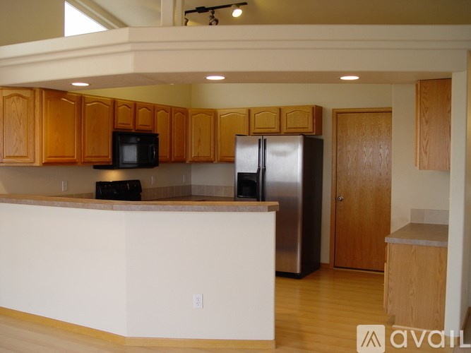 A kitchen with wooden cabinets and a white counter.