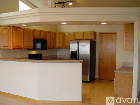 A kitchen with wooden cabinets and a white counter.