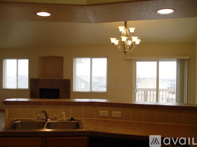 A kitchen with a sink, a stove, and a chandelier.
