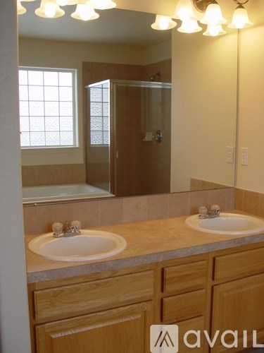 A bathroom with two sinks and a large mirror.