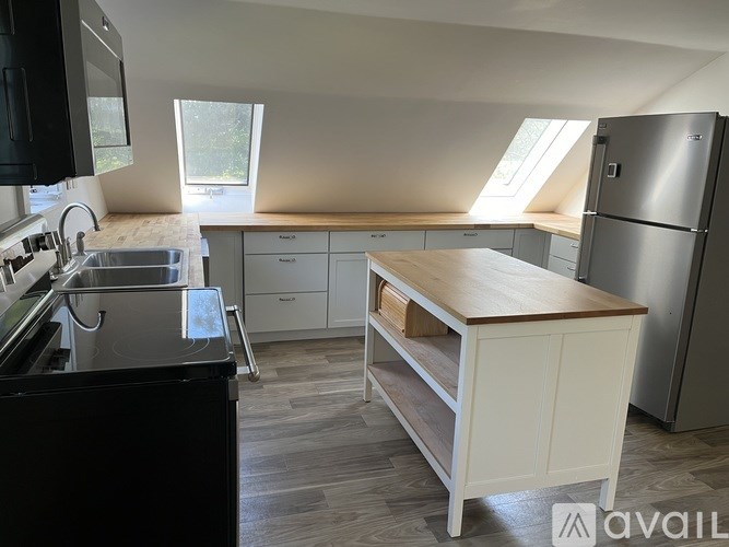 A kitchen with a black countertop and a wooden island.