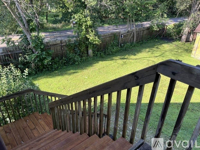 A wooden staircase with a railing leads up to a grassy area.