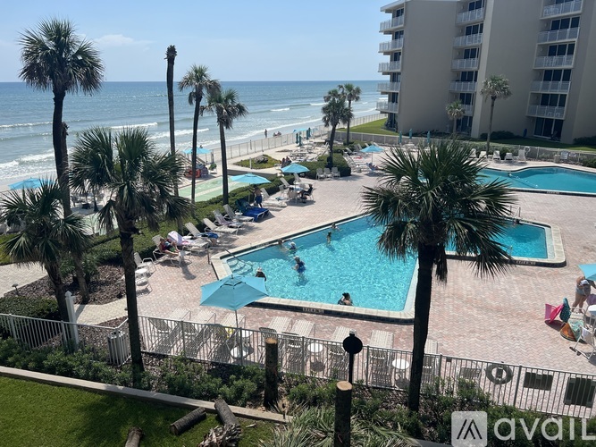 A pool area with people swimming and sunbathing.