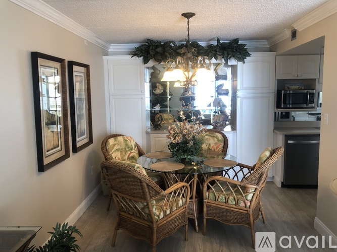 A dining room with a table set for four and a chandelier.