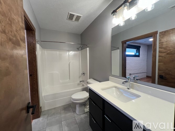 A bathroom with a toilet, sink, and shower.