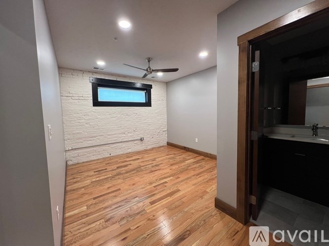 A room with wooden flooring and a ceiling fan.
