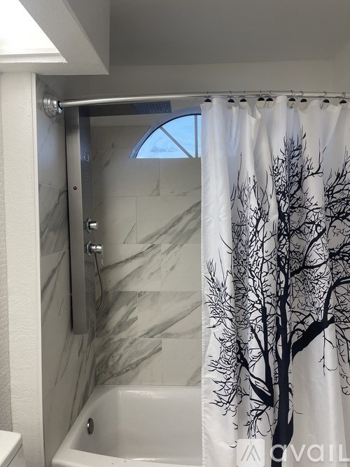 A bathroom with a tree design on the shower curtain.