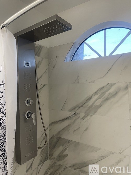 A shower with a grey body and a white curtain.