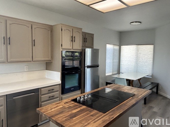 A kitchen with a wooden island and stainless steel appliances.