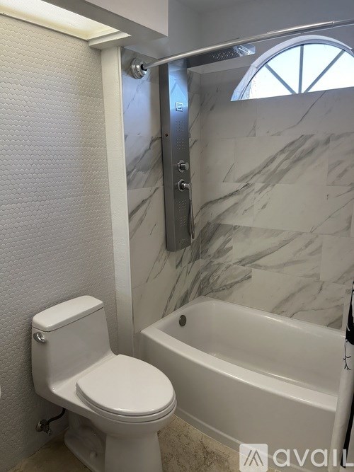 A white toilet sits next to a bathtub in a bathroom.