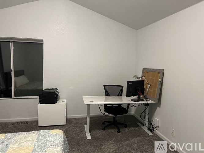 A small room with a desk and a bed.