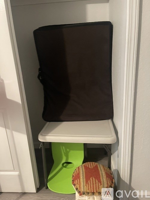 A brown pillow is on a white chair.