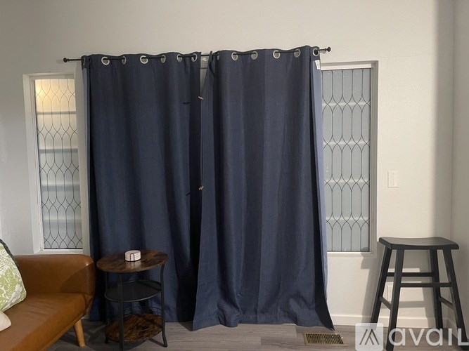 A dark blue curtain hangs in a living room.