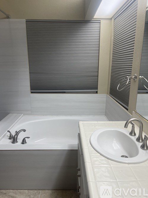A white bathroom with a tub and sink.