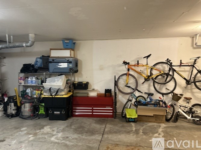 A garage with bicycles and a vacuum cleaner.