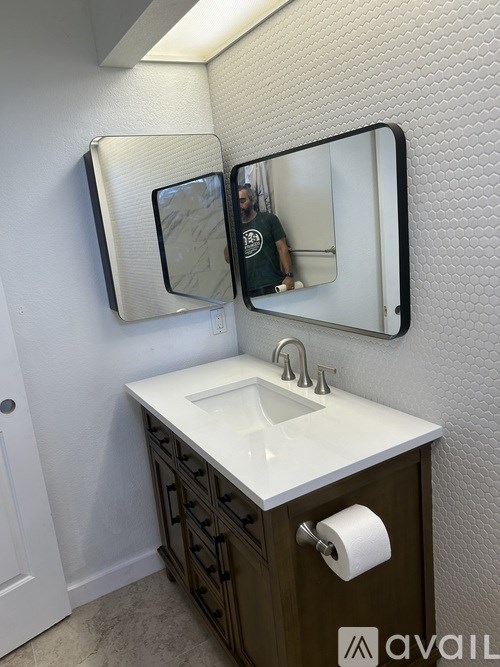 A bathroom with a white sink and brown cabinetry.