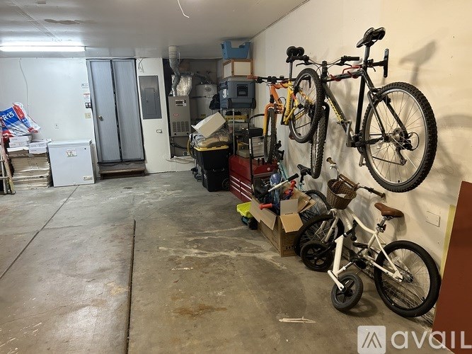 A room with a white wall and a bicycle hanging on it.
