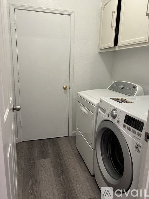 A white door is open to a laundry room with a washer and dryer.