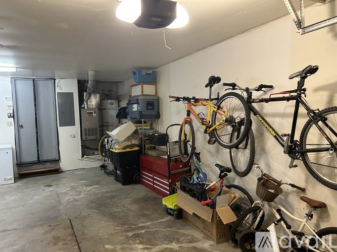 A garage with bicycles and a red toolbox.