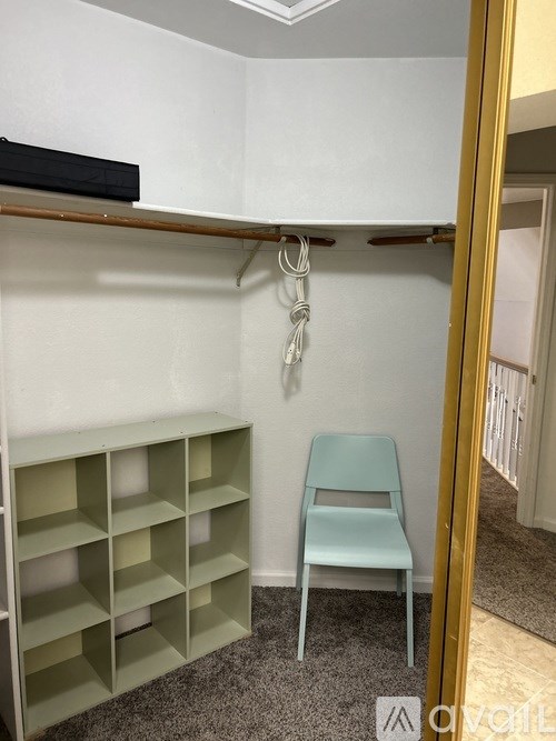 A room with a grey shelf and a blue chair.
