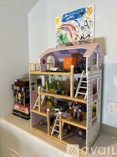 A dollhouse with a ladder and toys inside.