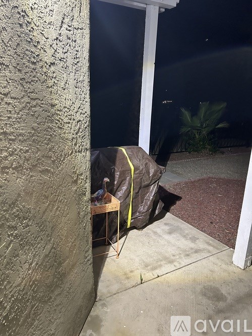 A person is sitting on a chair outside at night.