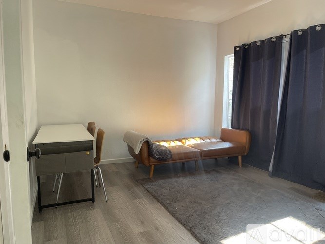 A room with a bed, a chair, and a desk.