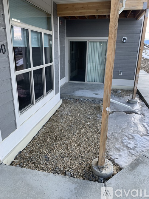 A house with a grey exterior and a white door and window.