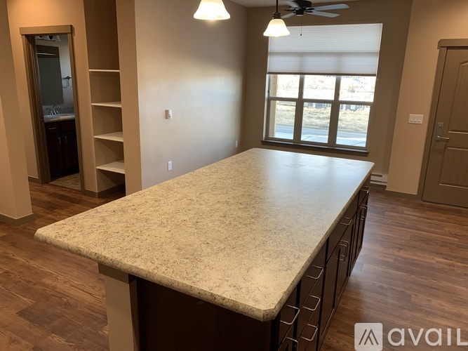 A spacious room with a large table and a ceiling fan.