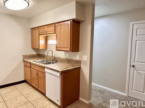 A kitchen with wooden cabinets and a white dishwasher.