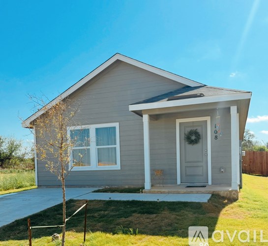 A small house with a grey front and a white door.